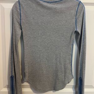 Free People gray textured top with blue stitching and zipper sleeves